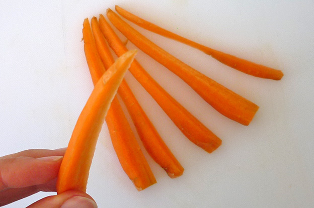 Food art with tomato, cutting carrot sticks, cutting a carrot with a narrow root step 2