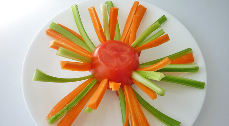 Food art with tomato, inserting vegetable sticks into the tomato saucer base, finish